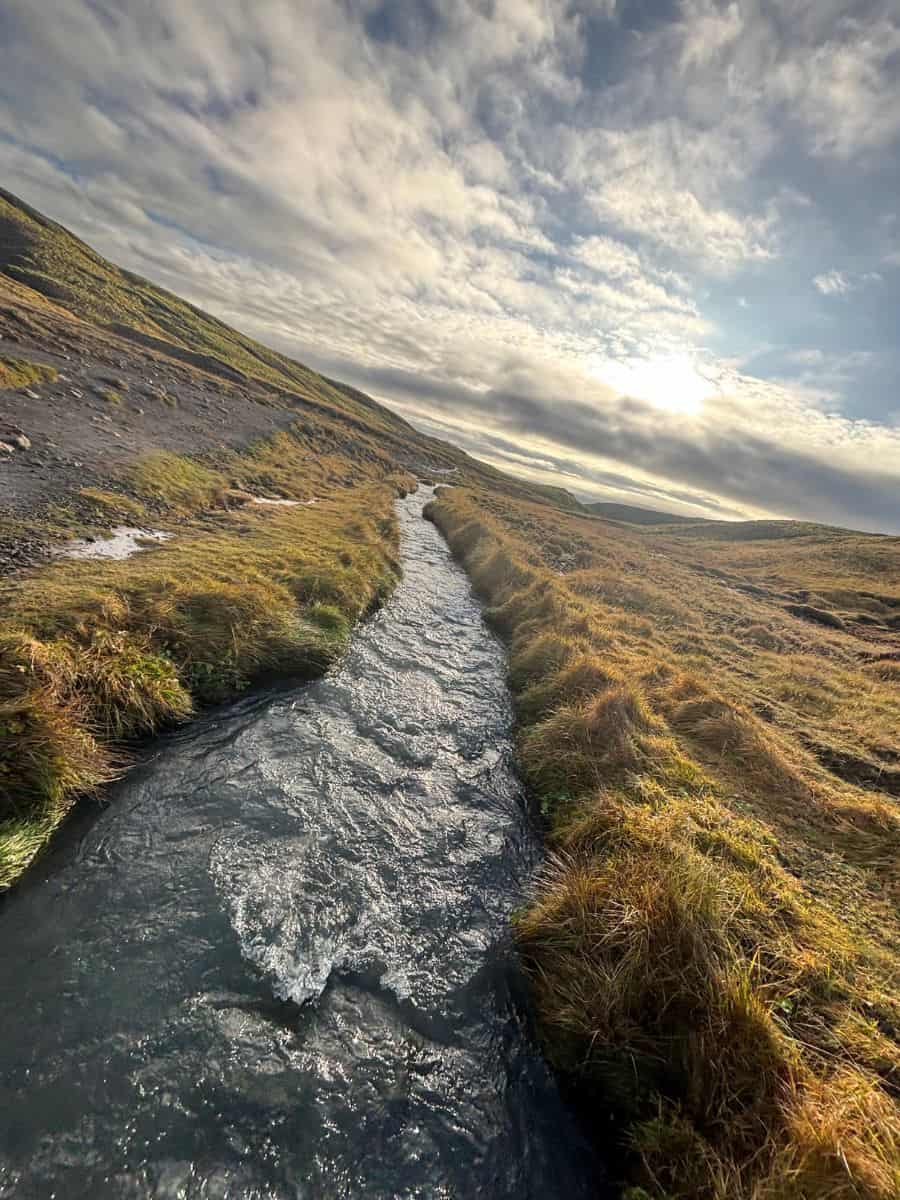 Water flowing through green mountains