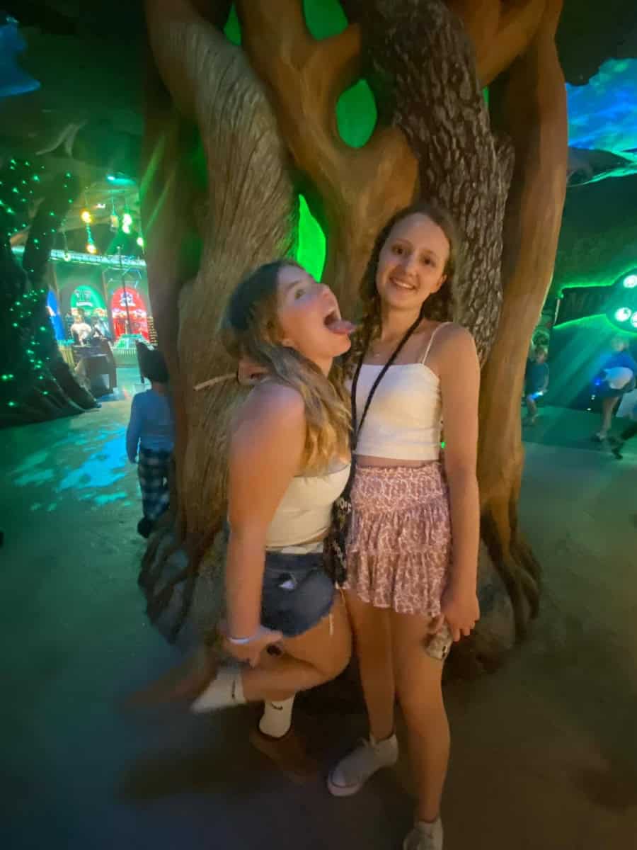 Two teen girls posing in front a tree at Great Wolf Lodge