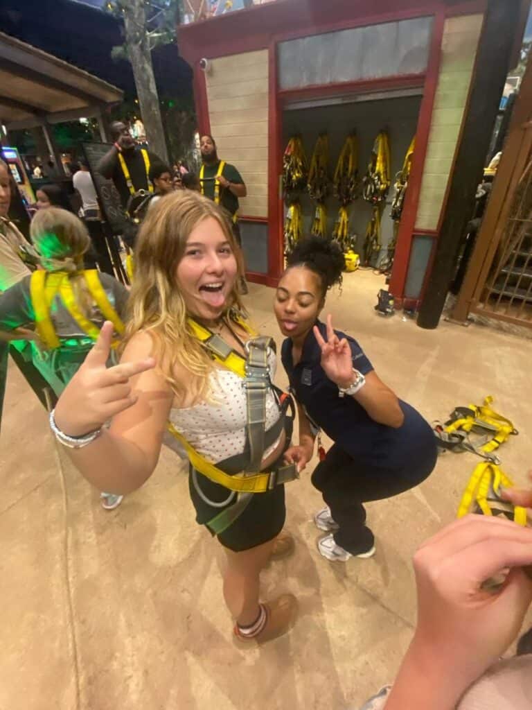 A teen girl getting fitted with a harness at Great Wolf Lodge