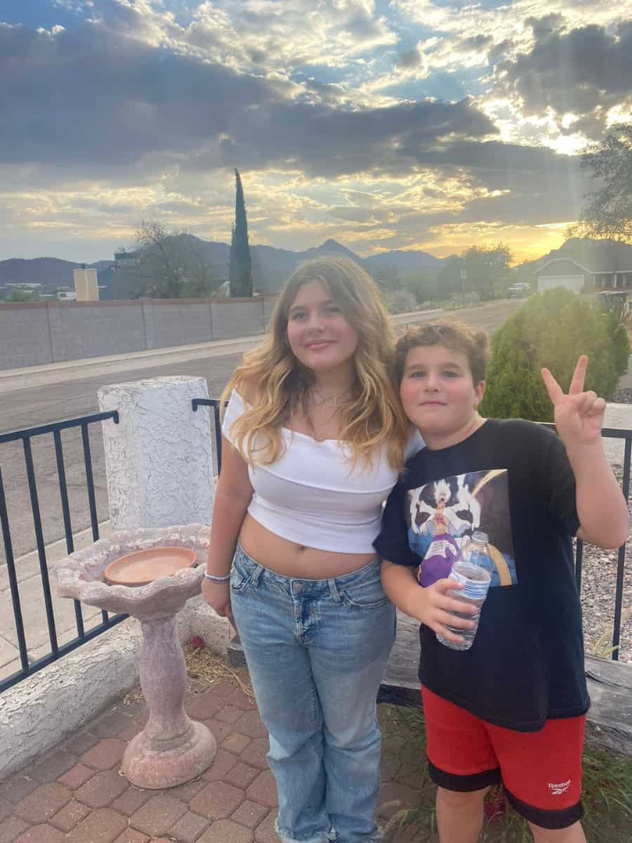 Teenage girl and tween boy posing at sunset