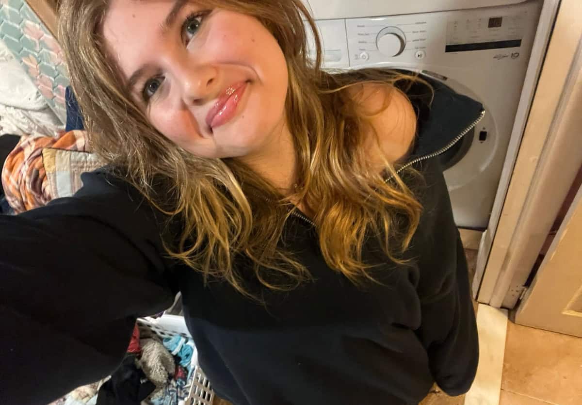 Teenage girl taking a selfie by the laundry machine