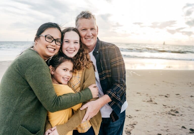 Family portrait on the beach with a mom, dad, teen and tween