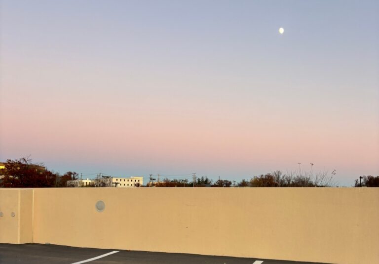 Moonrise over a parking lot, illustrating the beauty in everyday moments.