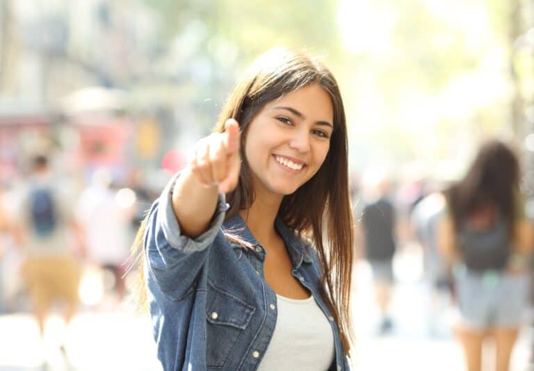 A smiling teen pointing at the camera