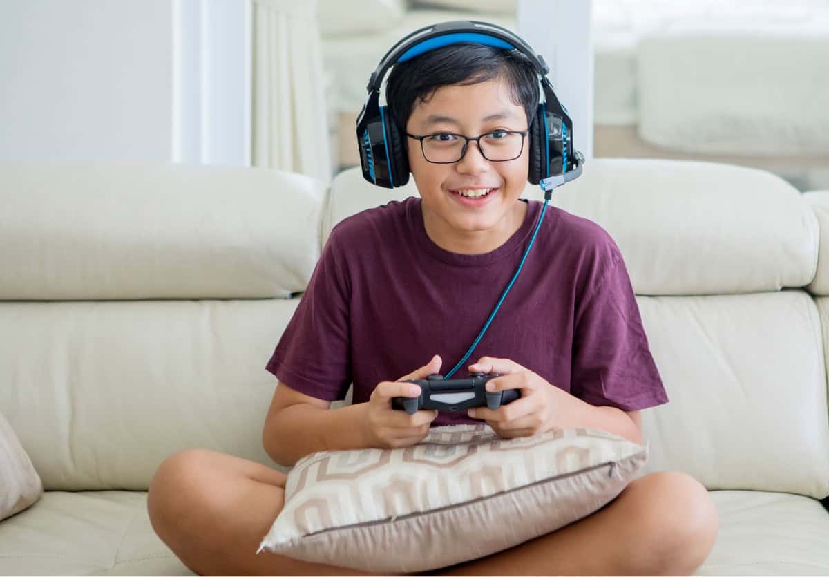 Teen boy wearing a headset while playing video games at home