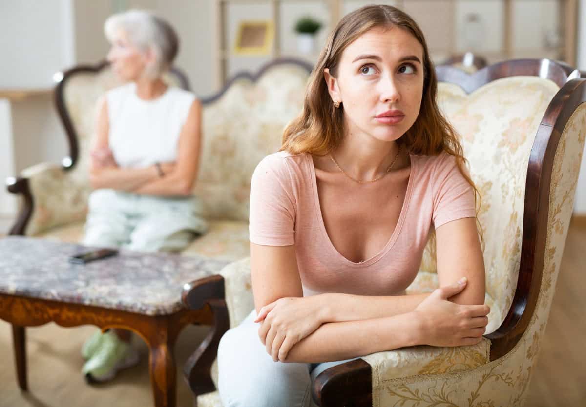 daughter and elderly mom on couch not speaking