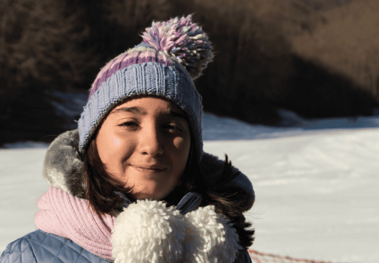 Portrait of a teen girl smiling in the snow.