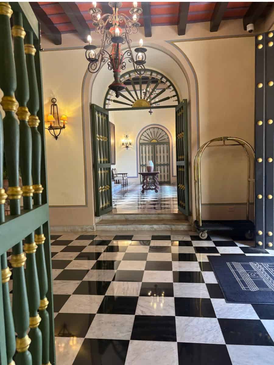 Entrance to El Convento Hotel with checkered floors and green and gold accents