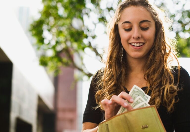 Teen taking dollar bills out of her wallet