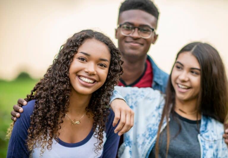 three teens smiling into the camera